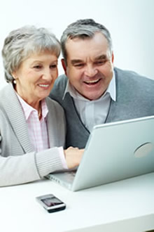 Älteres Paar glücklich vor dem Notebook